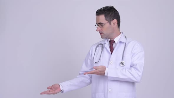 Handsome Man Doctor Showing Something Against White Background