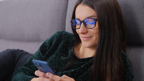 Brunette woman in glasses using mobile phone for communication and online dating in 4k video