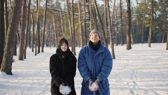 Young Happy Couple Throwing Snow in the Winter Park