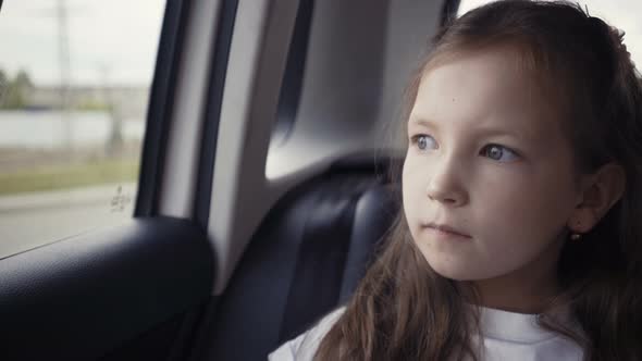 Girl Looking Out From Car Window at Sunny Day