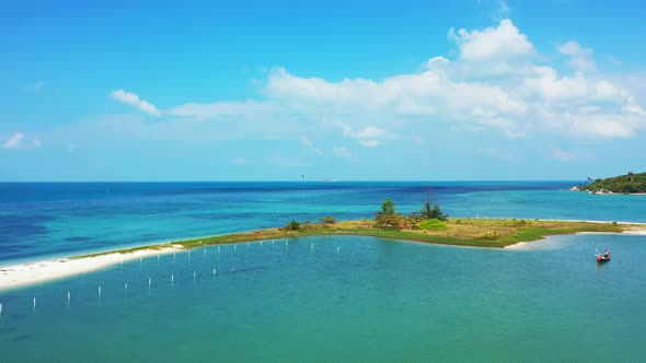 Peaceful seascape, calm clear water of turquoise lagoon washing white sand around tiny tropical isla