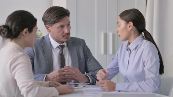 Male and Female Business Person having Serious Discussion in Office