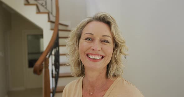 Portrait of smiling caucasian woman looking at camera at home