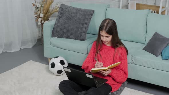 Beautiful Girl Making Notes of Online Lecture Lesson Sitting on the Floor Carpet