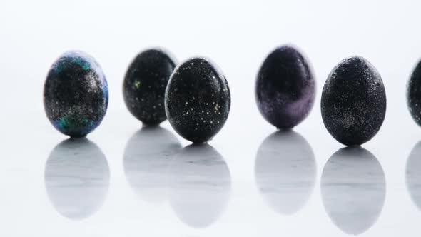 Cinematic shot of black color Easter egg on marble surface.  Color easter eggs on marble surface. Cl