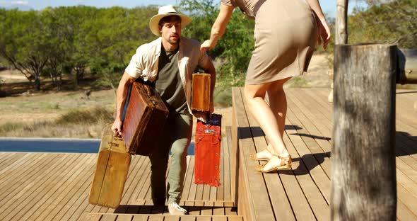 Woman helping the man in carrying suitcase 4k