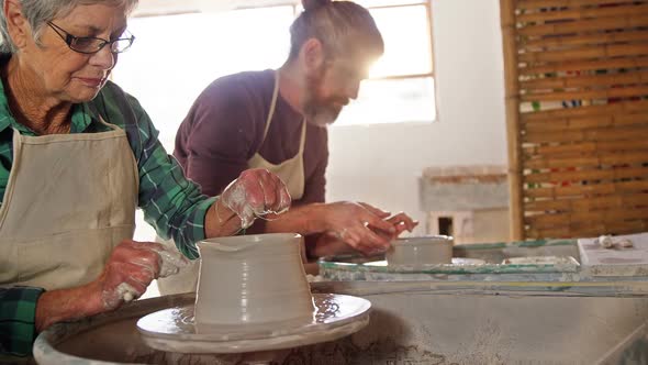 Male and female potter working together