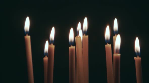 Many Candles Are Spinning on a Stand. Black Background