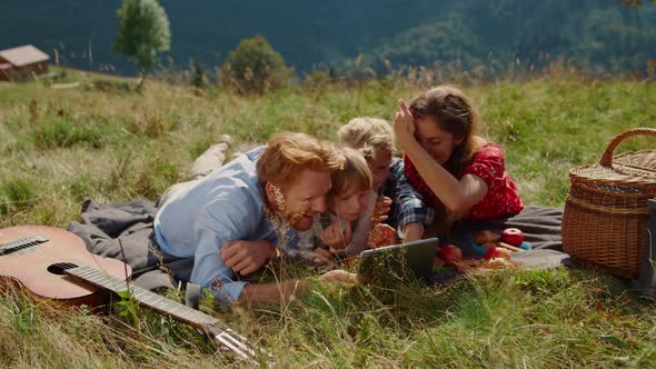 Family Using Tablet Picnic in Mountains Hill