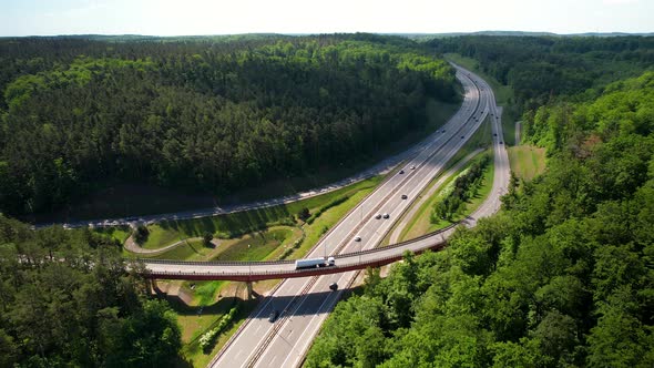 Elevated Highway And Expressway With Driving Cars, Dense Green Forest In Gdynia, Poland - aerial pul