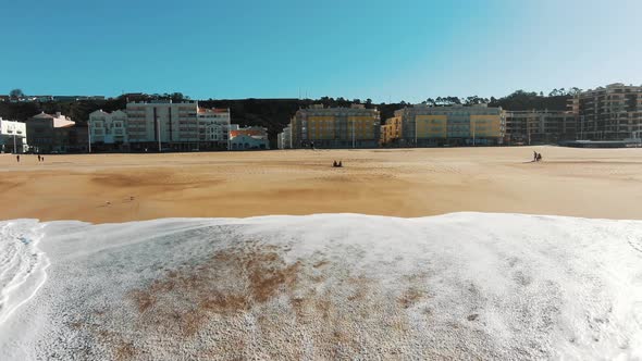 Huge Ocean Waves Roll on Sand Beach Against City Resort
