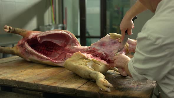 Butcher Cutting Fresh Meat at Pork Factory