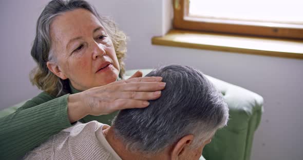 Elderly Woman Hairstyles Husband Strokes His Head Helping to Tuck His Hair