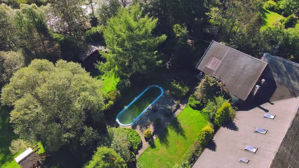 Old Abandoned Swimming Pool with Dirty Green Water. Flight Over a Beautiful Green Area with an