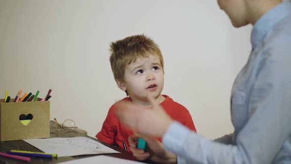 Elementary School. Mom and Her Toddler Son Pupil Plays at Home.