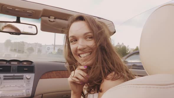 Young beautiful and smiling hipster girl in convertible car