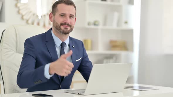 Positive Businessman with Laptop Doing Thumbs Up