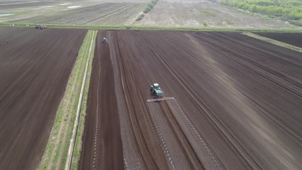 Tractor on Agricultural Lands Is Cultivated with Fertilizers