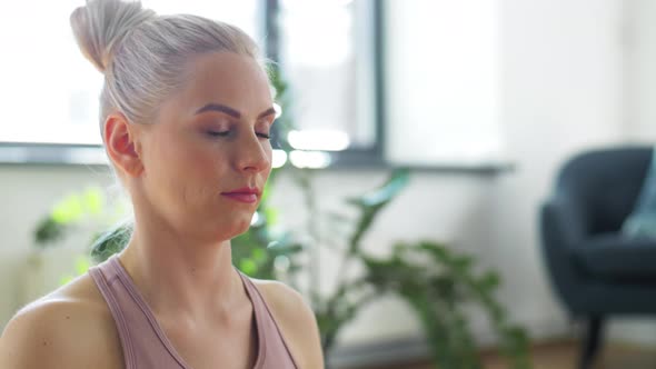 Woman Meditating in Lotus Pose at Yoga Studio