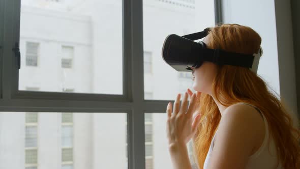 Woman using virtual reality headset in living room