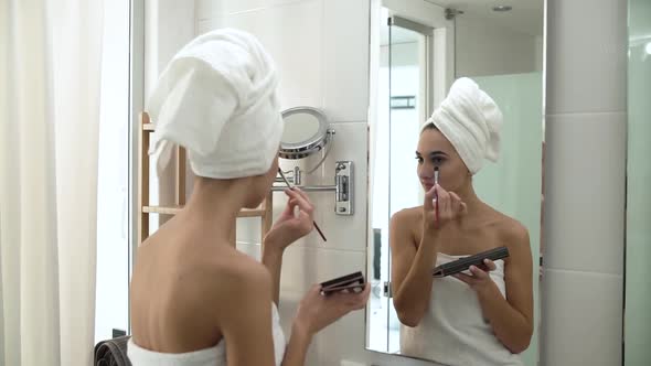 Makeup. Woman Applying Eyeshadows And Looking At Mirror