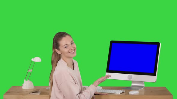 Charming Woman Presenting Something on the Screen of Computer Talking To Camera Blue Screen Mock-up