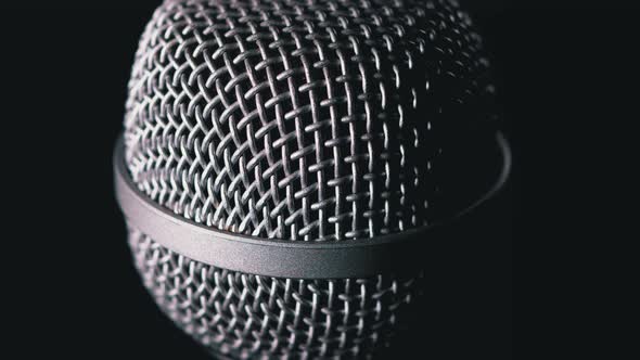 The Microphone Rotates on a Black Background. Dynamic Microphone Grid Spins Close-up alt