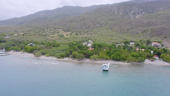 Wooden gazebo on pier at Bahia de Ocoa bay in Dominican Republic. Aerial drone circling panoramic vi