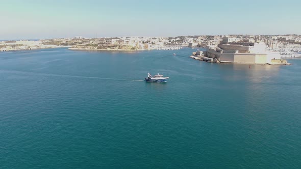 Motorboat passing by Fort St. Angelo, centre of Grand Harbour, Malta.