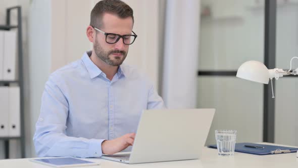 Middle Aged Man Having Neck Pain While Working on Laptop