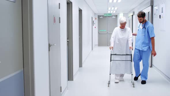Male nurse assisting senior patient in using a walking frame