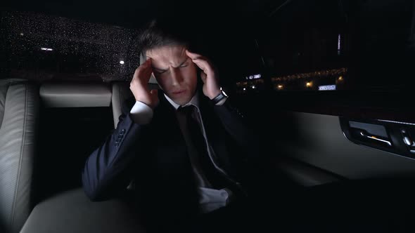 Businessman Massaging Temples in Car on Way Home, Strong Headache, Stressful Job