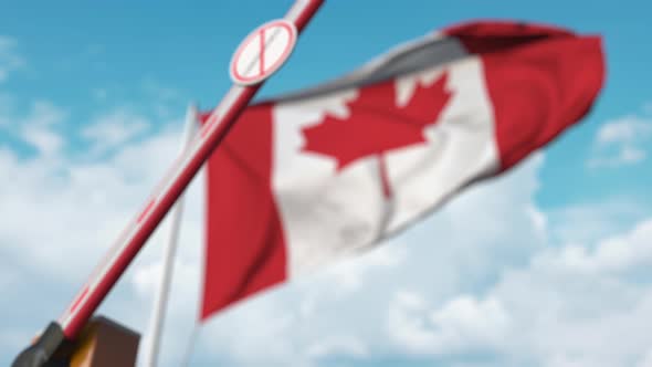 Closing Boom Barrier with STOP CORONAVIRUS Sign Against Canadian Flag
