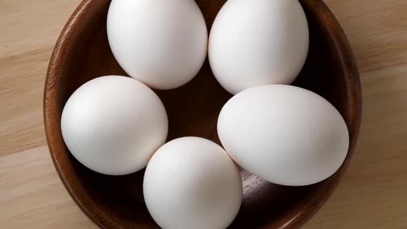 Eggs rotating in wooden bowl top view