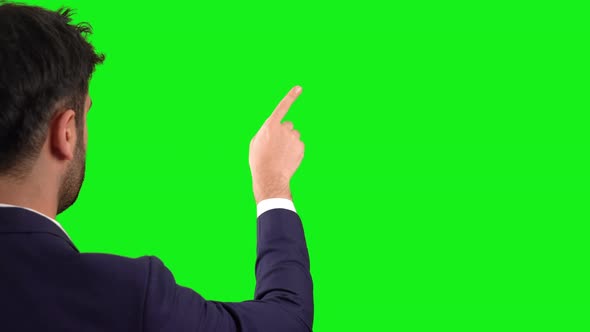 Businessman working on digital screen. Green background.