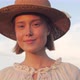 Portrait of Young Girl with Cute Face and Straw Hat standing on the Field. - VideoHive Item for Sale