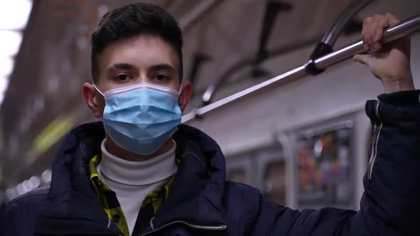 Young Male Student in Medical Mask Riding Metro