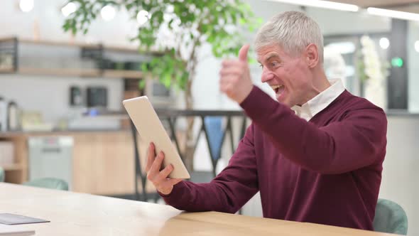 Excited Middle Aged Man Celebrating Success on Tablet