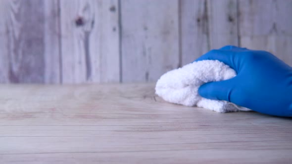 Hand Holding Spray Bottle and Cleaning Table 