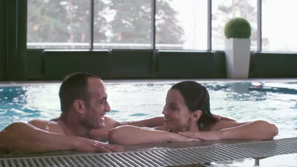 Woman Swimming and Chatting with Muscular Man