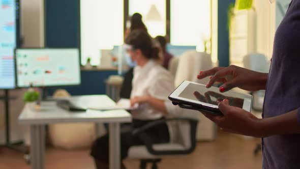 Close Up of African Employee Using Tablet Standing in Office