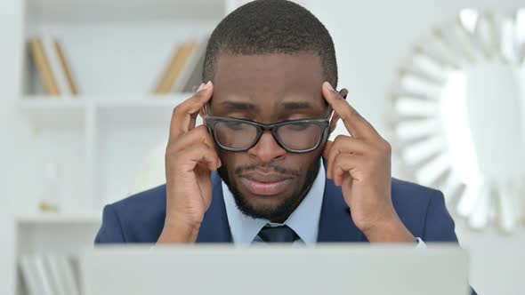 Portrait of African Businessman with Laptop Having Headache