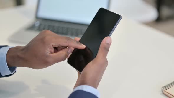 Hands of African Businessman Using Smartphone Close Up