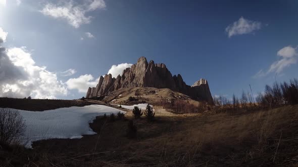 The rock disappears into the shadow of the clouds.