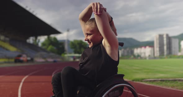 A Female Person with Disabilities Warming Up on Wheelchair at Athletics Training Track