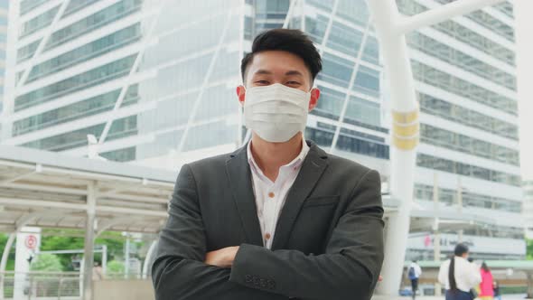 Portrait of Asian office businessman wearing mask standing outdoor in city with new normal lifestyle