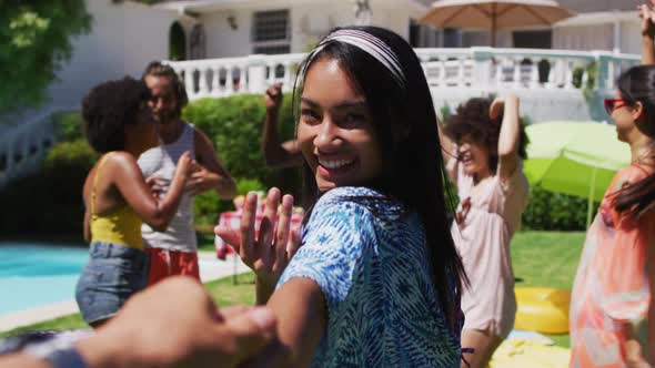 Diverse group of friends having fun and dancing at a pool party