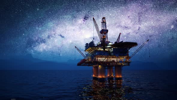 Offshore platform or oil rig in the open sea with milky way in the background.