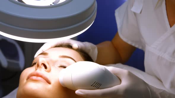 Doctor giving facial massage through soniclifting