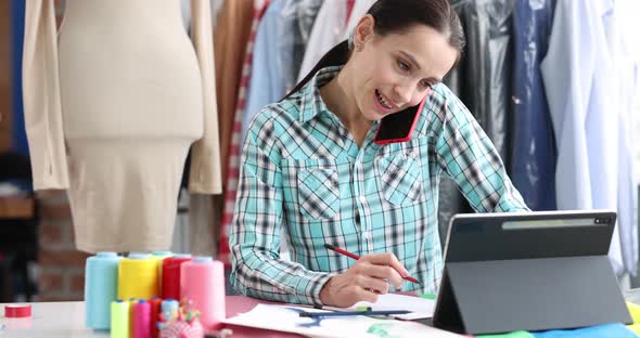 Woman Fashion Designer Takes an Order By Smartphone in Atelier Closeup